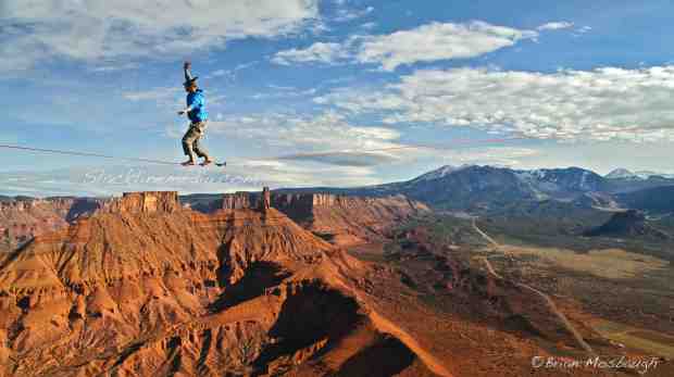 Local Moab climber/highline developer, Ryan Matson, takes a casual stroll in paradise atop Parriott Mesa on "Rim with a View." This location offers access to some of the most amazing tower climbs in the area with equally amazing views of Utah's staggering landscape. 